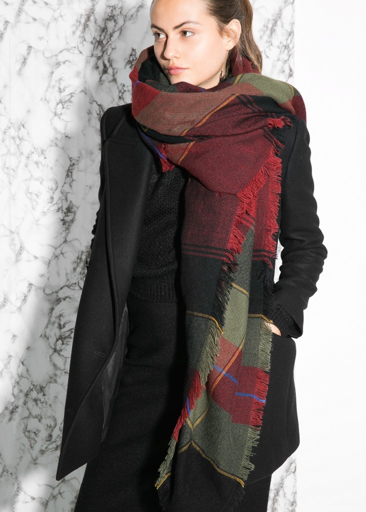 Woman in black trench coat with tartan scarf